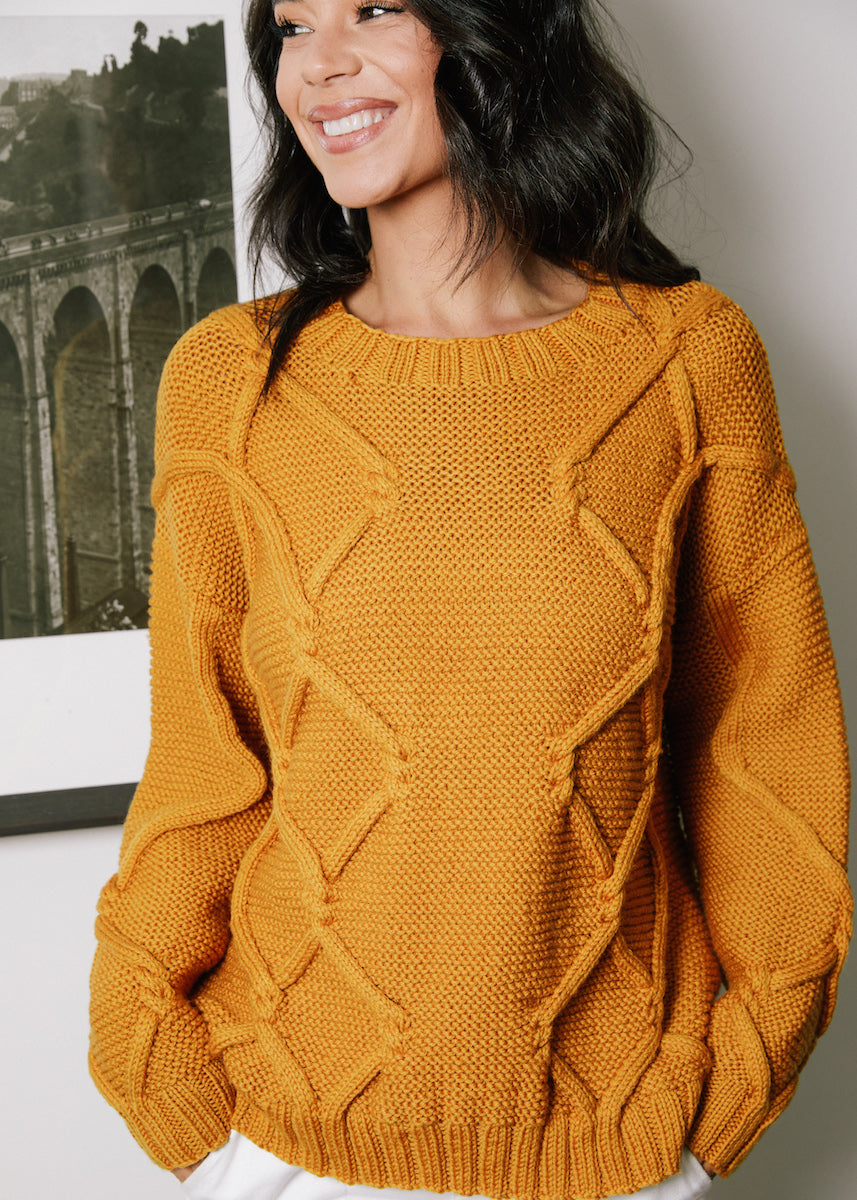 Travelling cable jumper, knitted in one to underarm.